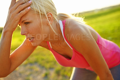 Buy stock photo A beautiful young woman in sportswear looking tired after a run