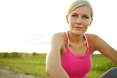 Buy stock photo A beautiful young woman sitting in a field after her jog
