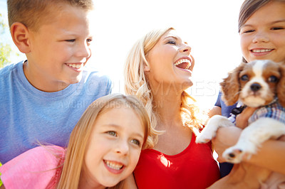 Buy stock photo Shot of a happy mother with her children and a puppy outside