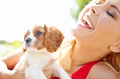 Buy stock photo Show of a laughing beautiful woman holding an adorable puppy outside