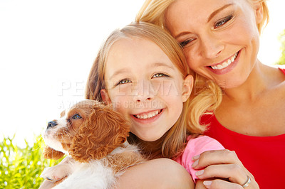 Buy stock photo Shot of a mother, daughter and puppy at bliss in the Outdoors with copyspace