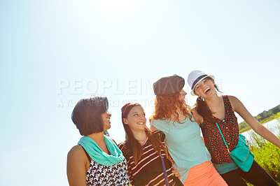 Buy stock photo Low-angle view of a group of teeange girls walking outside with their arms entwined