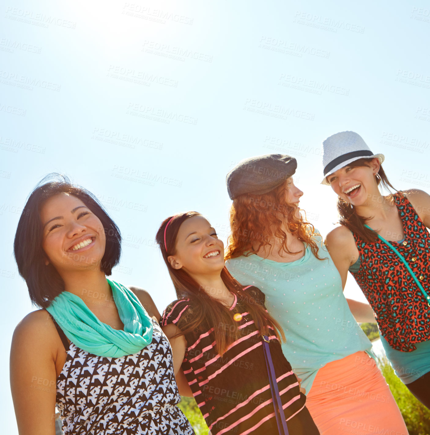 Buy stock photo Low-angle view of a group of teeange girls walking outside with their arms entwined