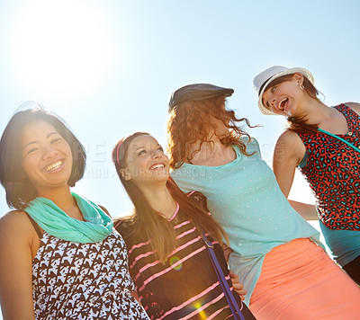 Buy stock photo Low-angle view of a group of teeange girls walking outside with their arms entwined