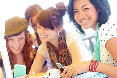 Buy stock photo A group of adolescent girls laughing as they look at something on a smartphone screen