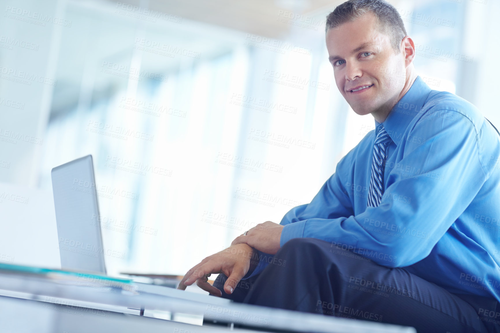 Buy stock photo A handsome young caucasian businessman working on his laptop