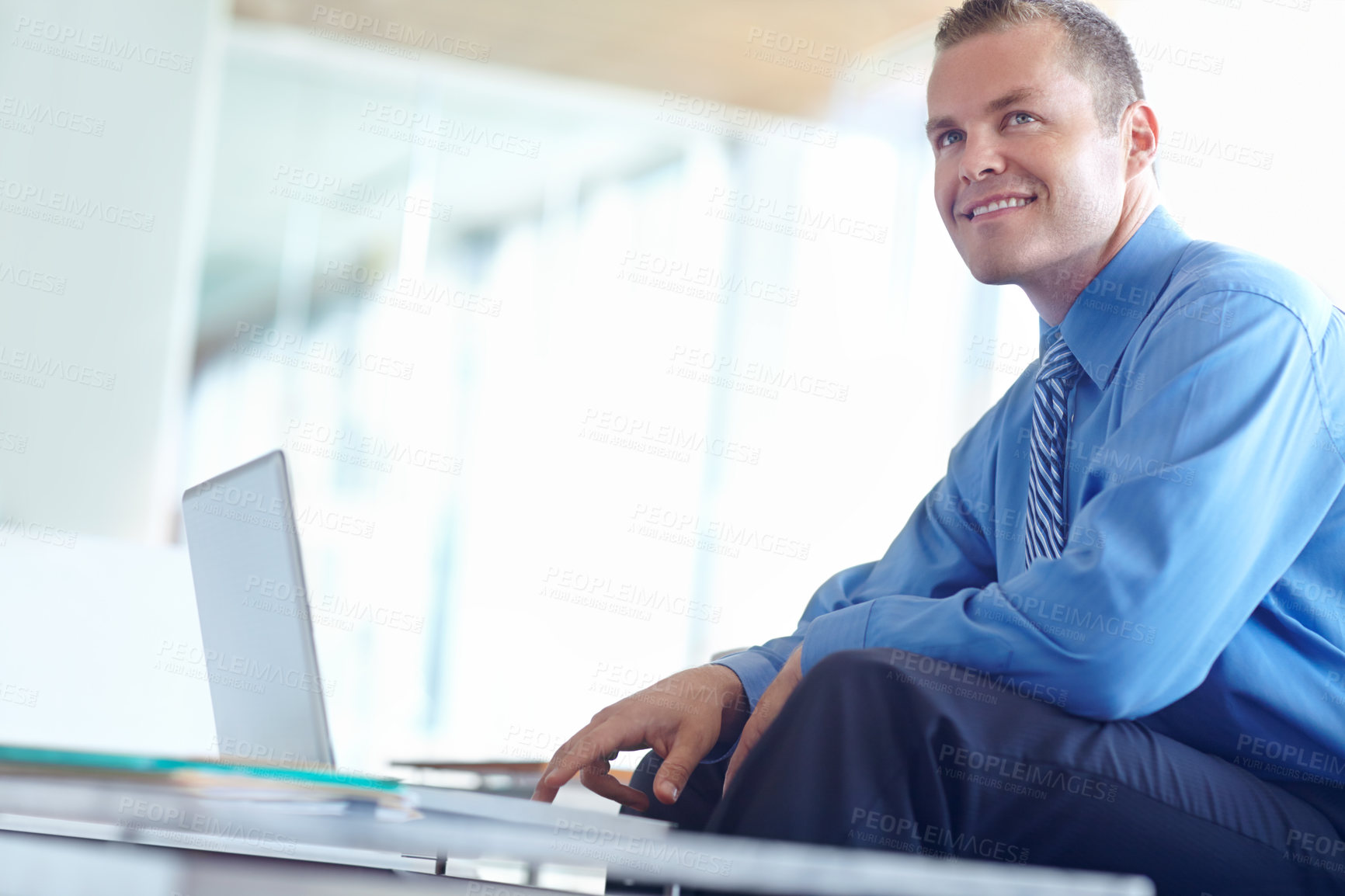 Buy stock photo A handsome young caucasian businessman working on his laptop