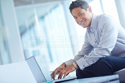 Buy stock photo An asian businessman using his laptop while at work
