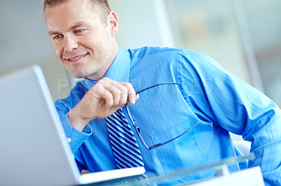 Buy stock photo Thoughtful young caucasian businessman working on his laptop 