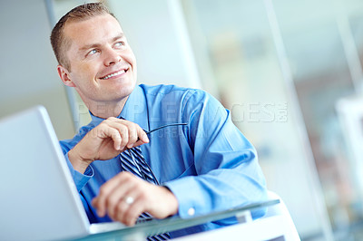 Buy stock photo Thoughtful young caucasian businessman working on his laptop 