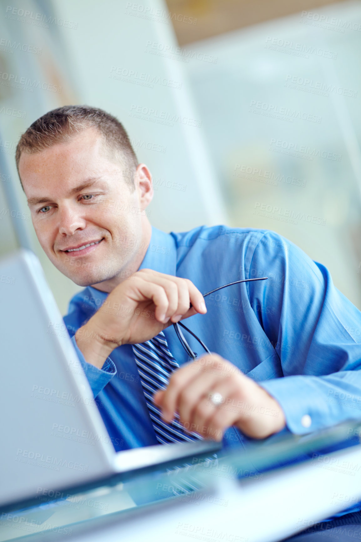 Buy stock photo Thoughtful young caucasian businessman working on his laptop 