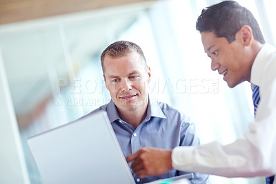 Buy stock photo Two successful business entrepreneurs working together and sharing a laptop
