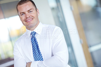 Buy stock photo Smiling caucasian businessman standing at work with his arms folded