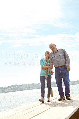 Buy stock photo Full length image of a mature couple strolling along the jetty