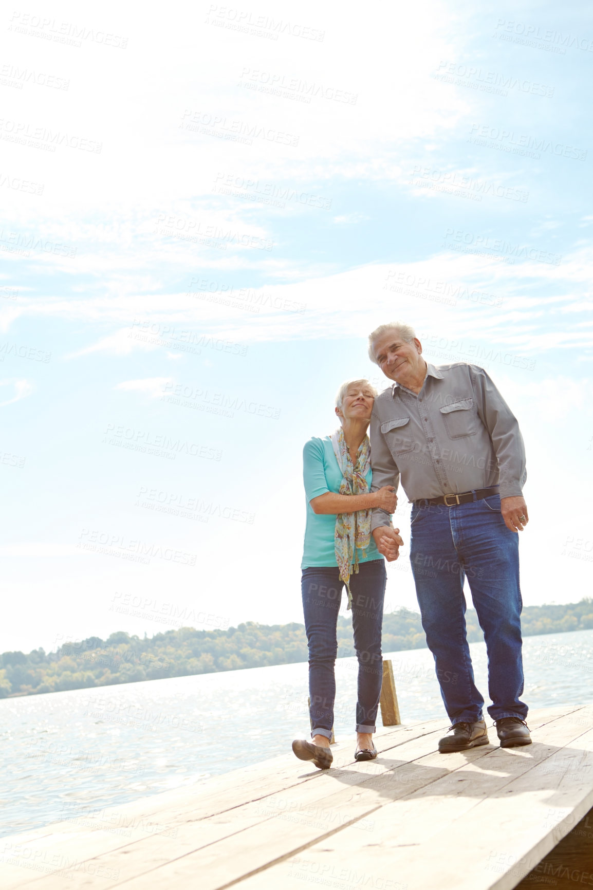 Buy stock photo Full length image of a mature couple strolling along the jetty