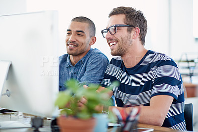 Buy stock photo Shot of two colleagues working together at a computer