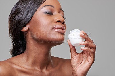 Buy stock photo Cropped studio shot of a beautiful young woman smelling her moisturizing cream