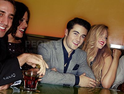 Buy stock photo A group of young adults enjoying cocktails in a night club
