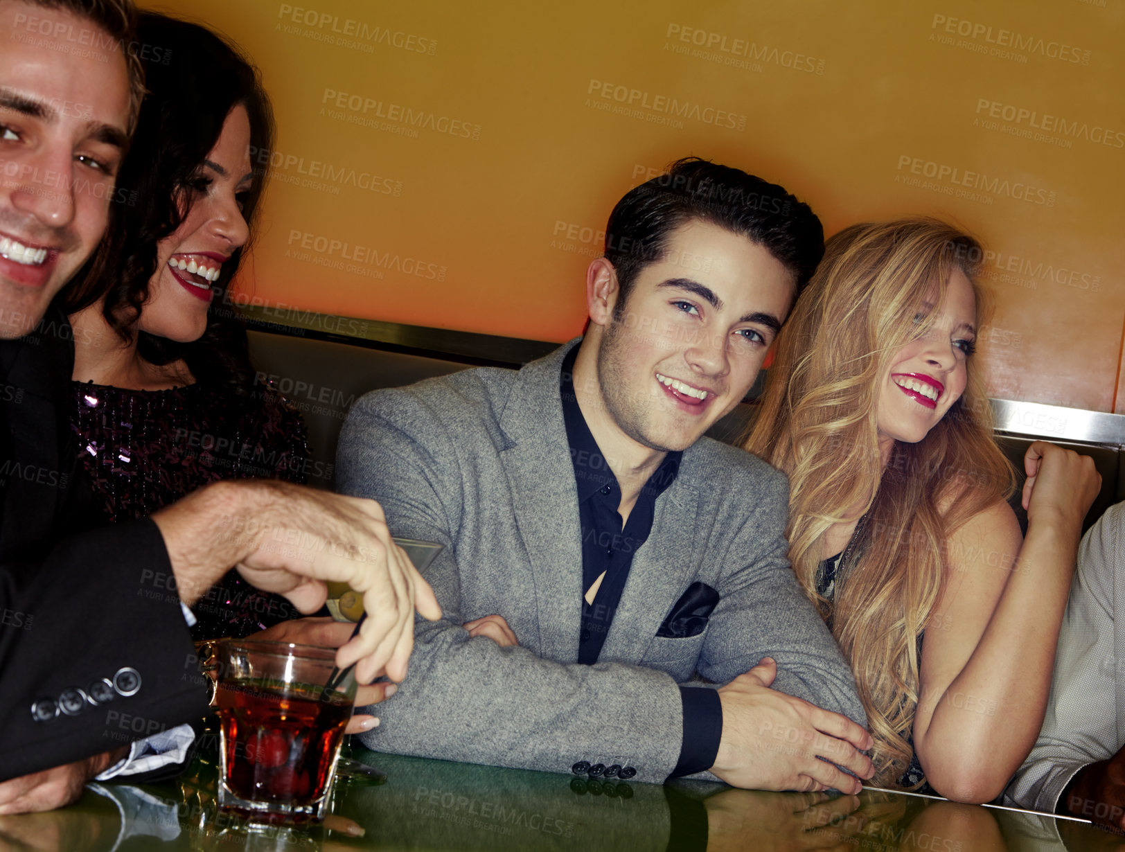 Buy stock photo A group of young adults enjoying cocktails in a night club