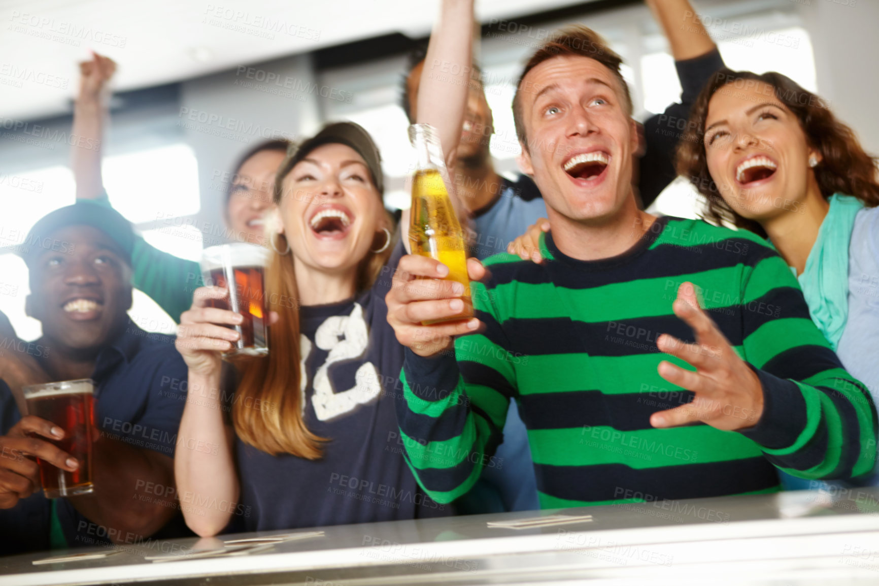 Buy stock photo A group of friends cheering on their favourite team at the bar