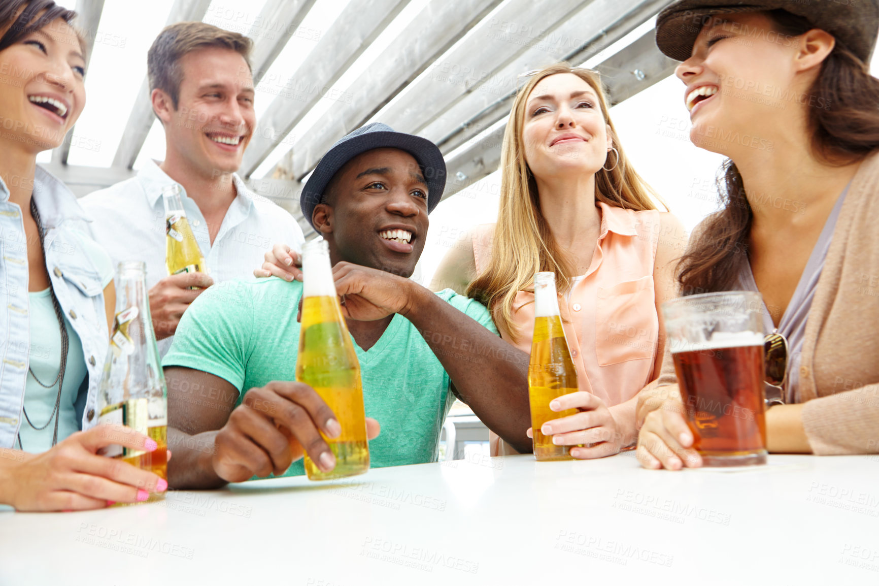 Buy stock photo A group of friends enjoying drinks on the deck of a trendy outdoors restaurant