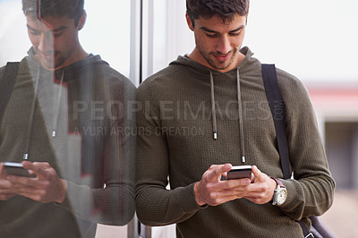 Buy stock photo Outdoor, smartphone and man in window reflection, texting and social media for student on campus. Technology, cellphone for scroll for male learner, internet or conversation online for entertainment