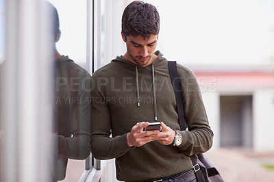 Buy stock photo Smartphone, texting and man outdoor, chat or social media for student on campus. Technology, cellphone for scroll for male learner, internet or online for entertainment or conversation at university