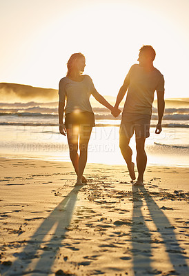 Buy stock photo Lens flare, sunset and couple holding hands at beach, ocean and sea with affection, bonding and love. People, partners and romance for care together on vacation, holiday and travel in Australia