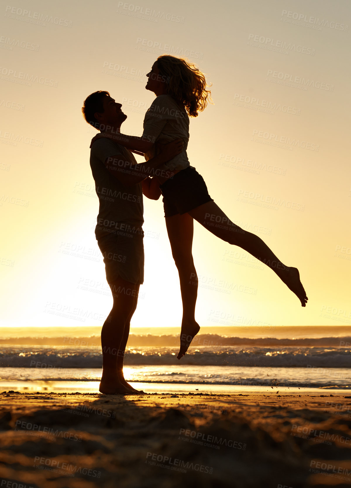 Buy stock photo Lifting, silhouette and couple with sunset at beach, ocean and sea for affection, love and to relax. People, partners and sunrise for care together on vacation, holiday and travel in Australia