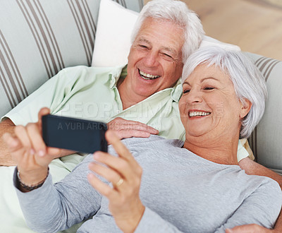 Buy stock photo Senior, happy couple and relax for selfie on sofa in living room with smile for photo, memory or profile picture at home. Elderly man and woman smiling for photograph, vlog or social media on couch