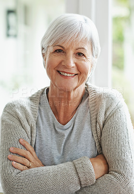 Buy stock photo A happy senior woman smiling at the camera as she sits in her home