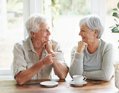 Buy stock photo Happy senior couple, coffee and smile for morning breakfast, relationship or bonding together at home. Elderly man and woman smiling with drinking tea cup or mug in relax, conversation or retirement