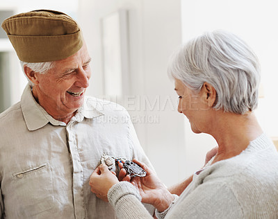 Buy stock photo Military veteran, man and woman with medal, uniform and smile together with memory, pride and success. Elderly couple, army badge or regalia with happiness, check and retirement from service in house