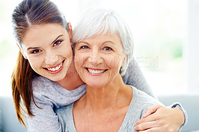 Buy stock photo An attractive young woman smiling alongside her senior mother