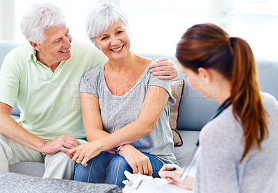 Buy stock photo A doctor explaining medical care to a senior patient and her husband