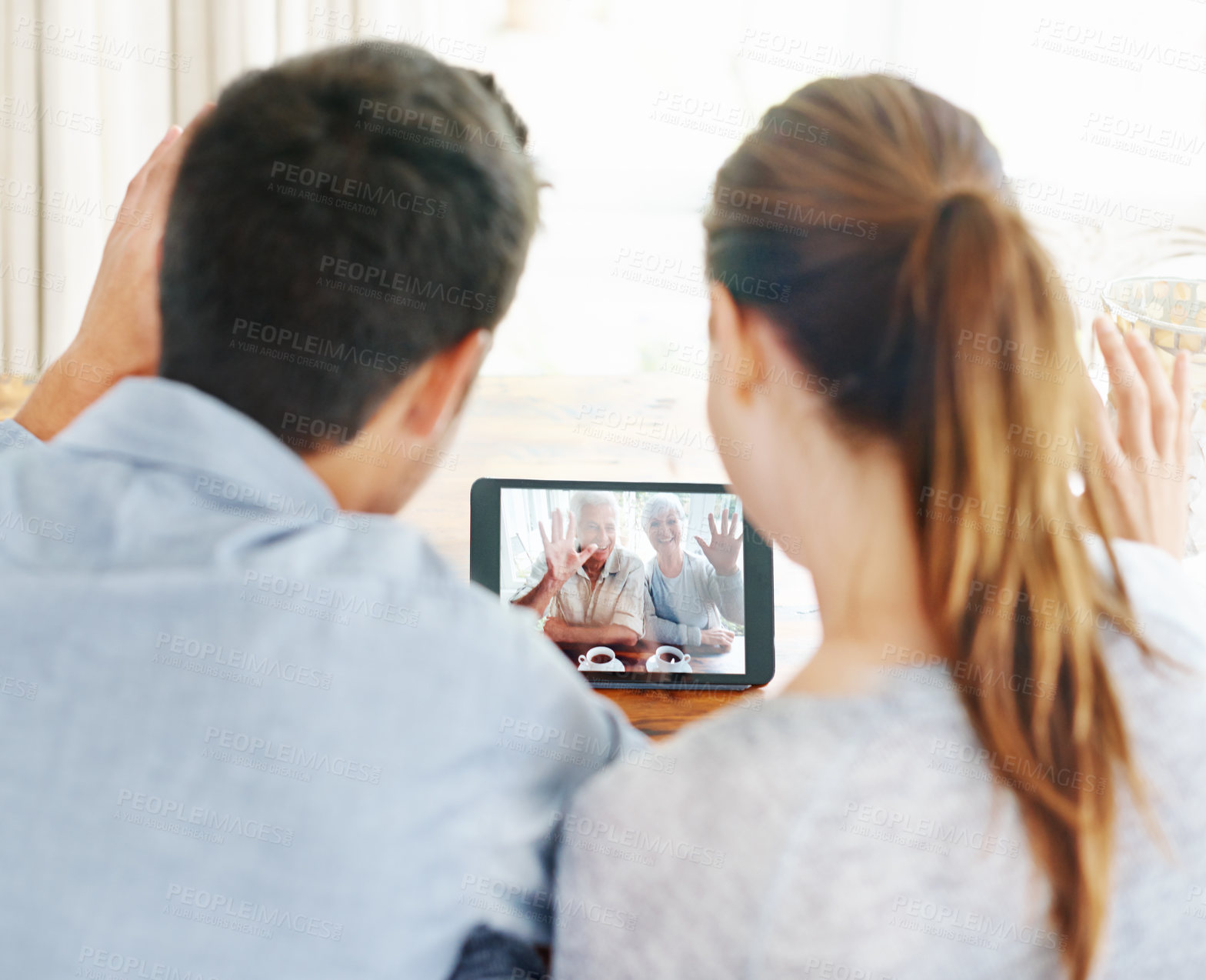 Buy stock photo Couple, tablet and video call with grandparents for greeting or online conversation at home. Rear view of man and woman talking or waving with technology for virtual meeting, talk or communication