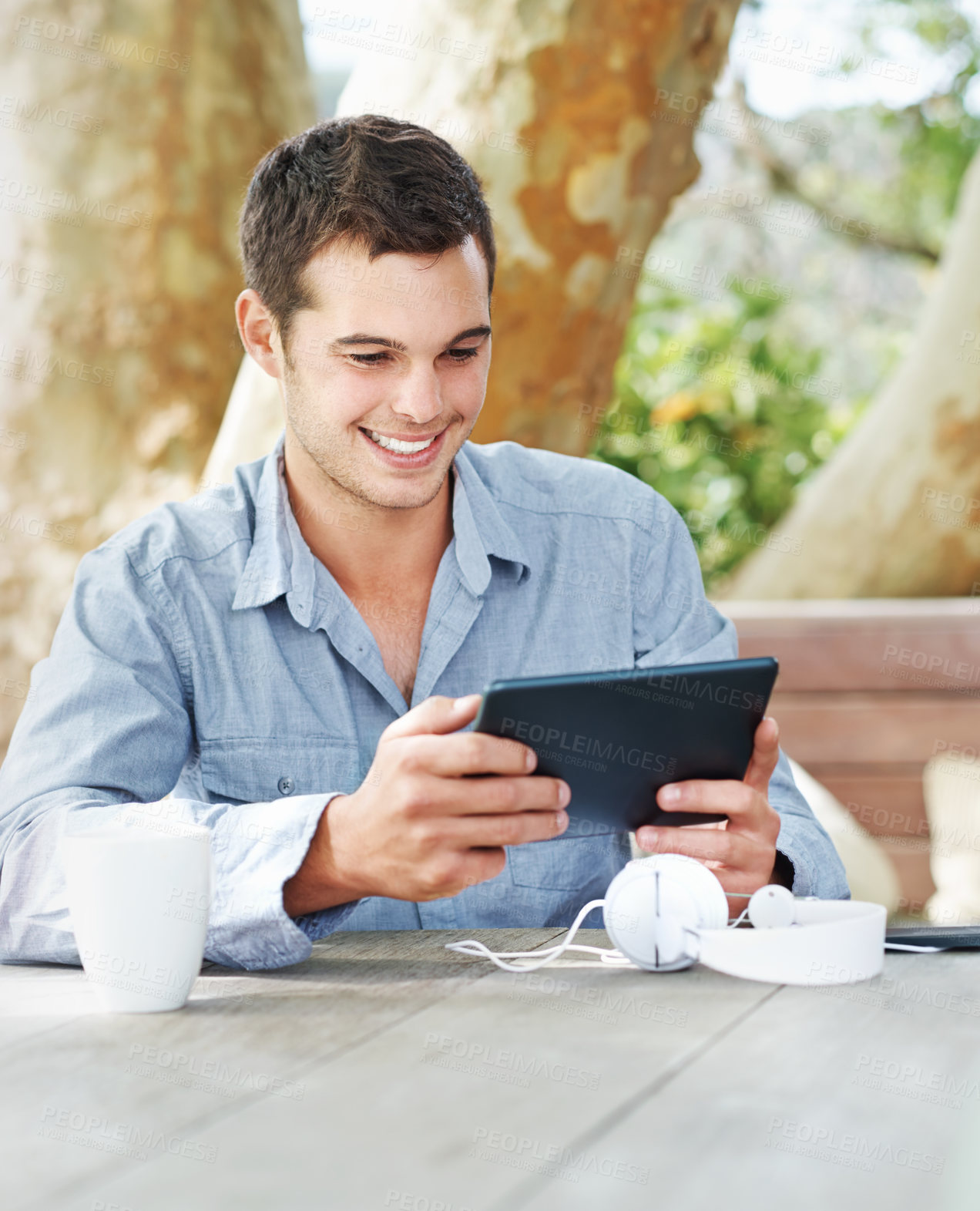 Buy stock photo Smile, park and man with tablet in nature on table for networking, email and freelance job. Happy, digital nomad and graphic designer with tech in garden for creative research, feedback and review