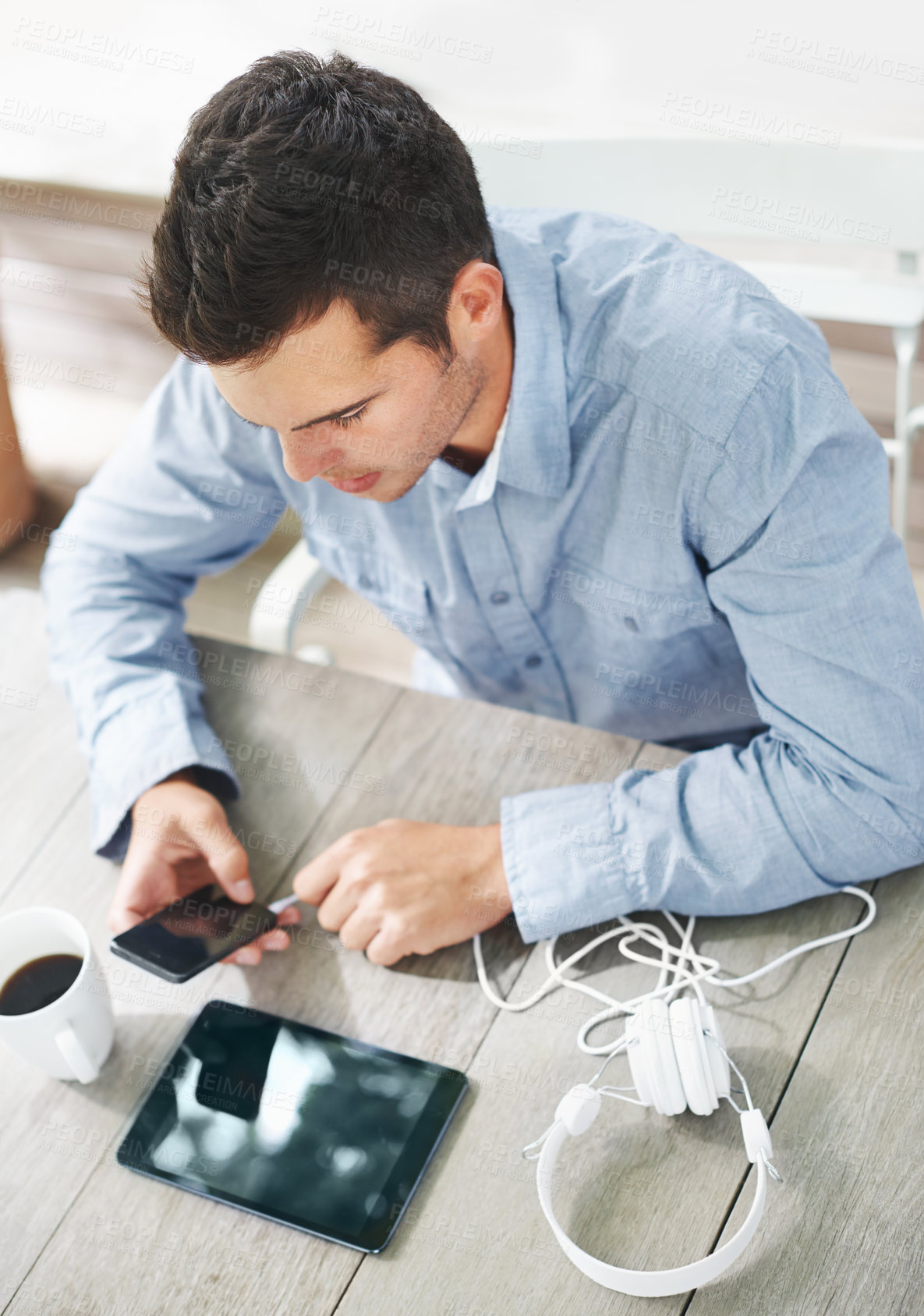 Buy stock photo Table, cafe and man with internet on smartphone for networking, communication and download of music. High angle, technology and male person with headphones for online search, audio book and website