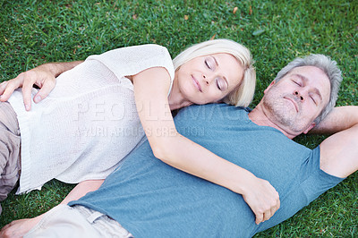 Buy stock photo Man, woman and mature or relax on grass for afternoon nap in nature backyard for resting, weekend or sleeping. Couple, embrace and bonding connection with peaceful calm in Australia, meadow or spring