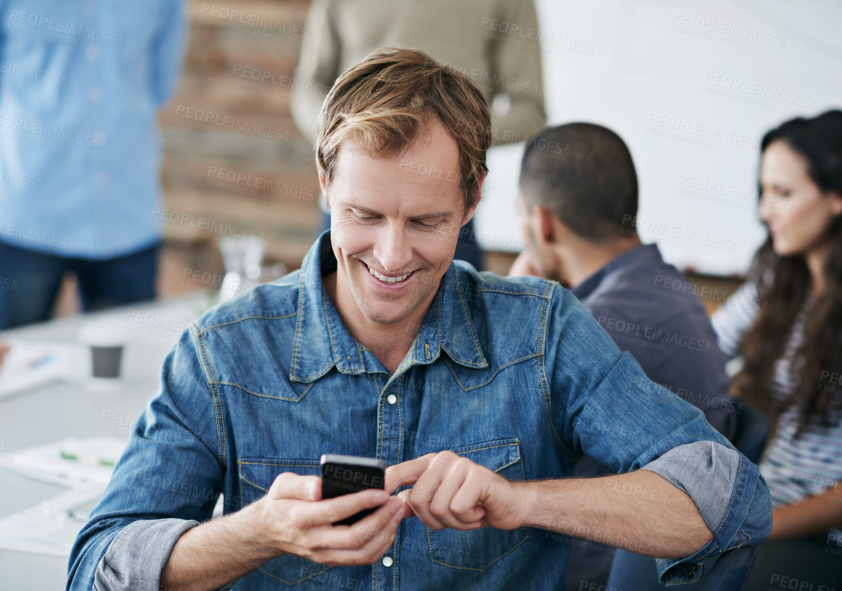 Buy stock photo Happy man, phone and typing with meeting for social media, communication or networking in boardroom at office. Young male person with smile on mobile smartphone for online chatting, texting or app