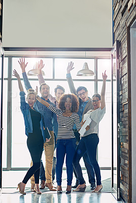 Buy stock photo Portrait of a group of cheering coworkers standing in front of a window in an office