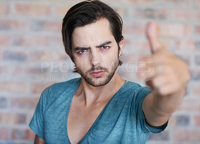 Buy stock photo Angry, portrait and man by brick wall with hand gun, confidence or edgy tshirt in Germany. Male person, face or cool model with violence gesture for shooting weapon, pistol fingers or self defence