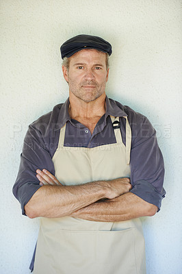 Buy stock photo A farmer in an apron standing with his arms crossed