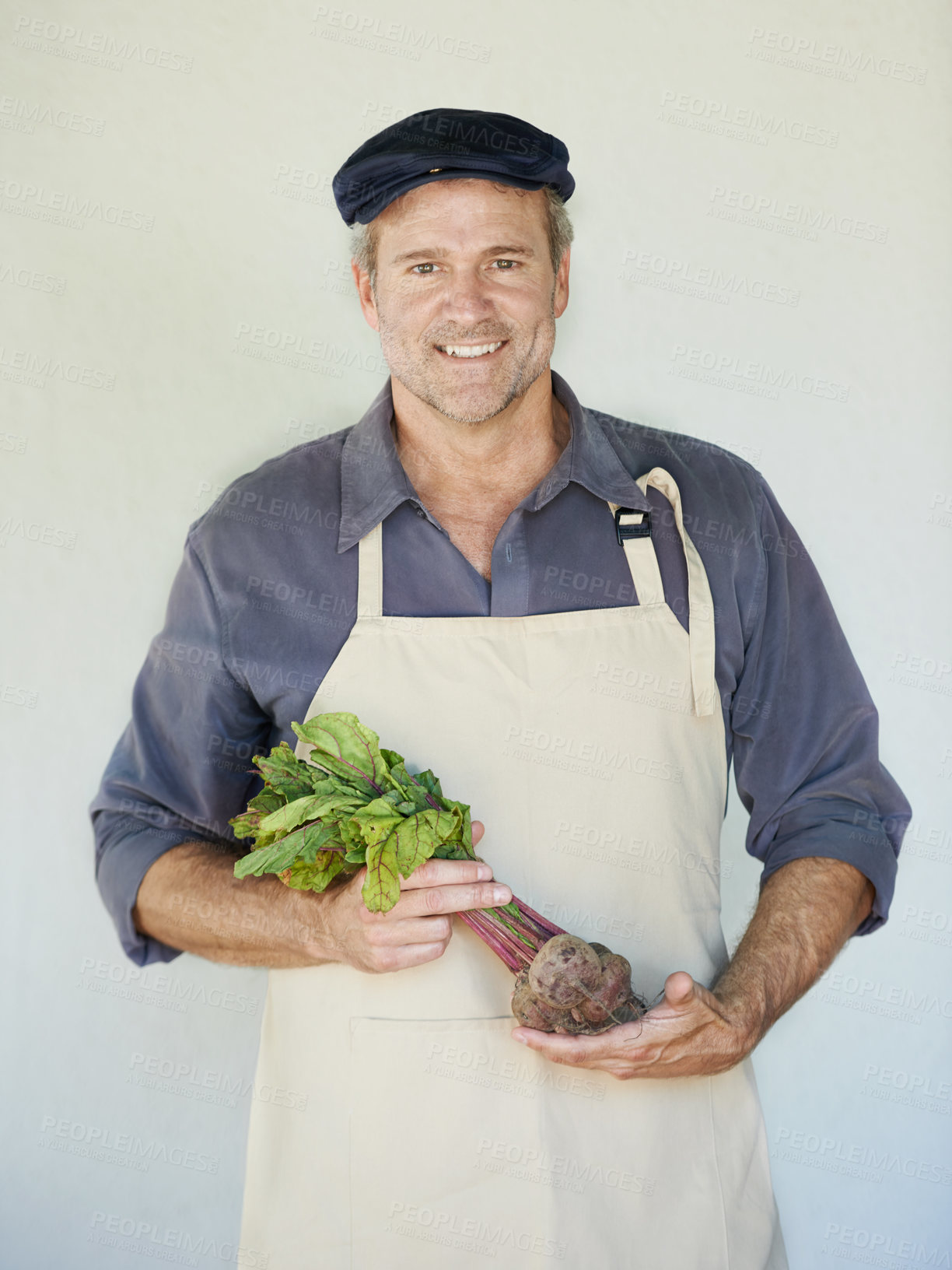 Buy stock photo Farmer, vegetables and portrait of man with onions for agriculture, harvest or organic food by wall. Growth, fresh produce and male person with apron for agro business, gardening or sustainability