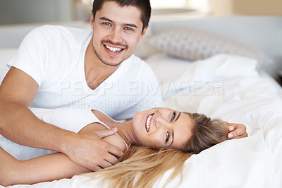 Buy stock photo Affectionate young couple lying together