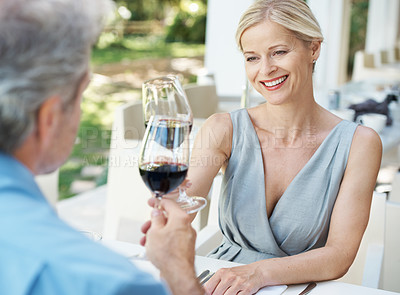 Buy stock photo Happy mature couple toasting their love with two glasses of wine while outdoors