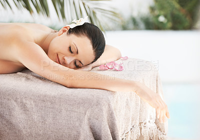 Buy stock photo A beautiful young woman lying on a massage table surrounded by rose petals