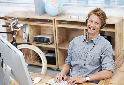 Buy stock photo Man, startup and headphones in portrait with typing, smile and computer for creativity for post on social media. Young businessman, entrepreneur and seo expert on web with music at small business