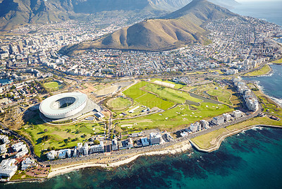 Buy stock photo Mountain, buildings and drone of ocean in nature for travel destination in city with stadium. Landscape, rocks and aerial view of scenic green environment by sea for tourism or holiday in Cape Town.