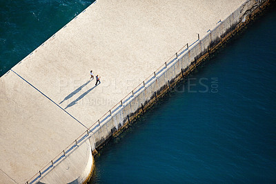 Buy stock photo Water, walking and aerial with people by pier for outdoor adventure, bonding and weekend trip. Nature, travel and friends by ocean on holiday for coastal vacation, summer and tourism in Australia